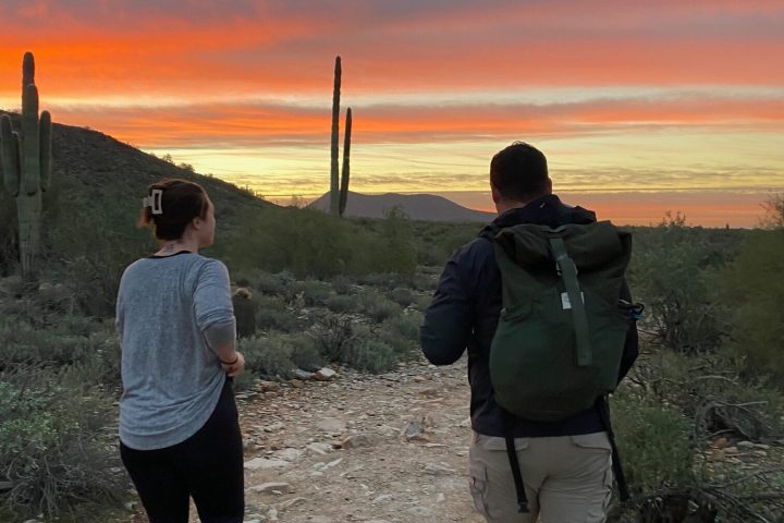 a couple of people standing on top of a hill